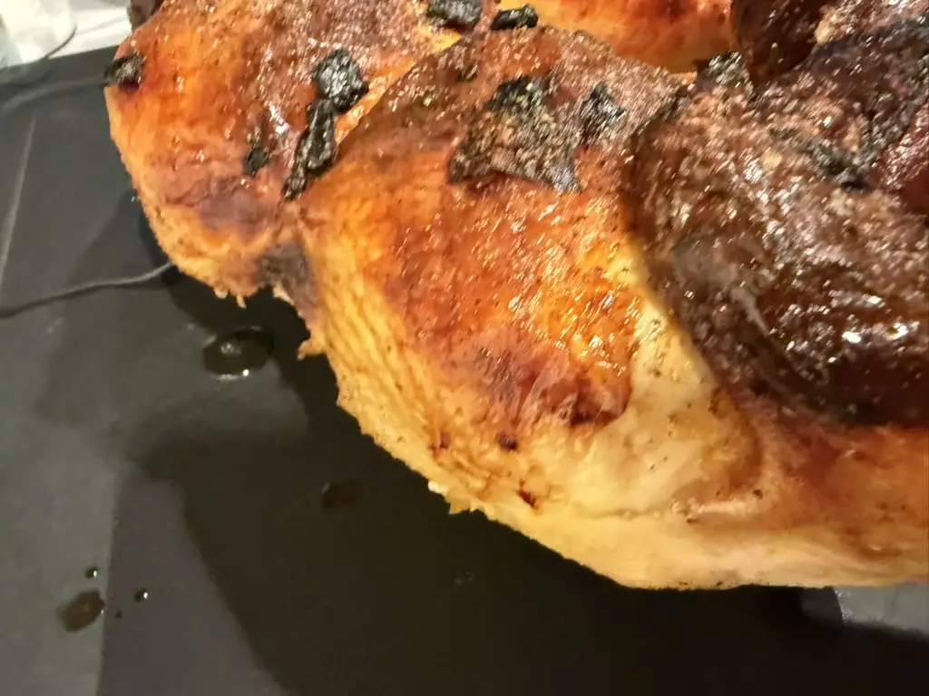 Close up of the chicken breast edge showing pale, thick, unrendered skin next to a well bronzed section