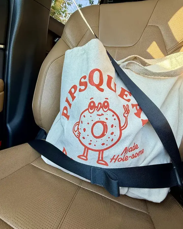 A bag of Pipsqueak bagels buckled into the car seat for the ride home