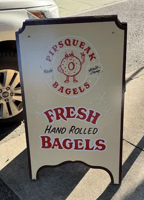The Pipsqueak Bagels sandwich board on the sidewalk: fresh, hand rolled bagels